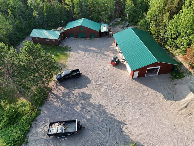 Cuttle Lake Resort, aerial still, 2026-07-10: the lodge yard, the workshop and the outbuildings from above