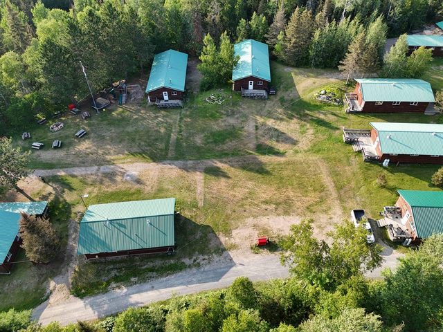 Cuttle Lake Resort, aerial still, 2026-07-10: the cabin row and the field between them