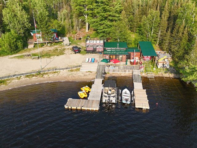 Cuttle Lake Resort, aerial still, 2026-07-10: the beach, the docks and the boats tied up